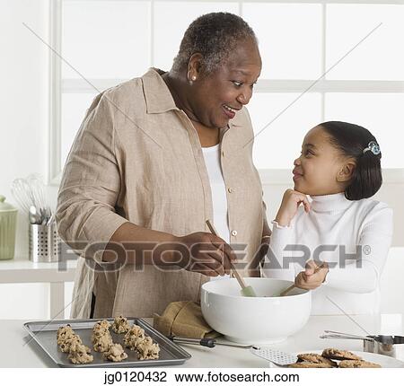 Senior woman making cookies with her granddaughter View Large Photo Image Stock Image - Senior woman making cookies with her granddaughter . Fotosearch