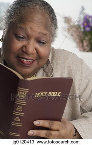 Stock Image - Senior woman reading the Bible. Fotosearch