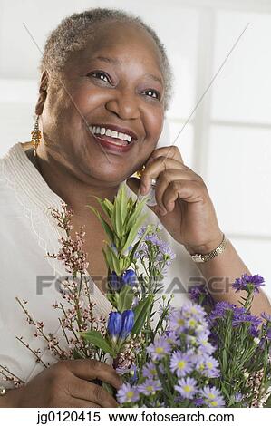 Stock Photography - Senior woman receiving flowers. Fotosearch