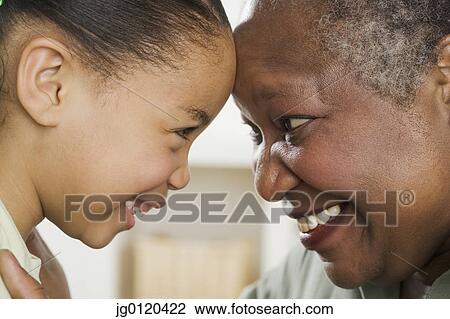 Stock Image - Senior woman smiling at her granddaughter. Fotosearch