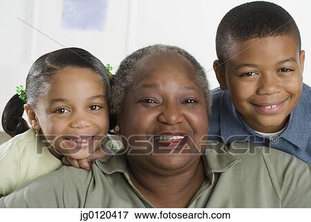 Senior woman smiling with her grandchildren View Large Photo Image Stock Photo - Senior woman smiling with her grandchildren. Fotosearch