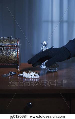 Thief reaching for a string of pearls View Large Photo Image Picture - Thief reaching for a string of pearls. Fotosearch