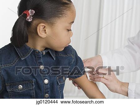 Picture - Young girl getting a shot. Fotosearch