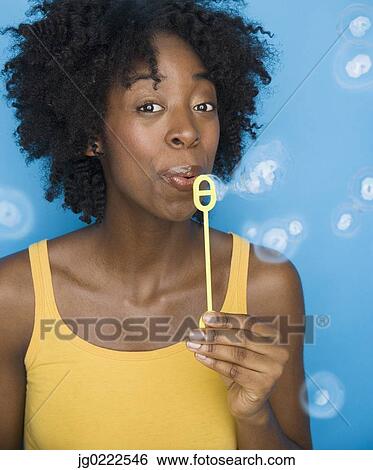 Young woman blowing bubbles View Large Photo Image Stock Photograph - Young woman blowing bubbles. Fotosearch