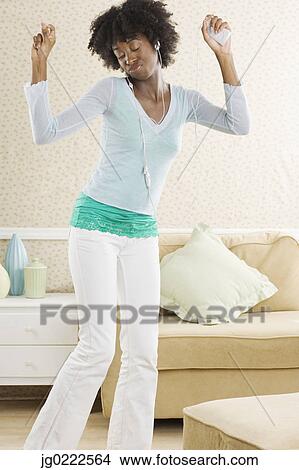 Young woman dancing while listening to her headphones View Large Photo Image Picture - Young woman dancing while listening to her headphones. Fotosearch