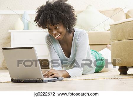 Young woman using a laptop View Large Photo Image Stock Image - Young woman using a laptop. Fotosearch