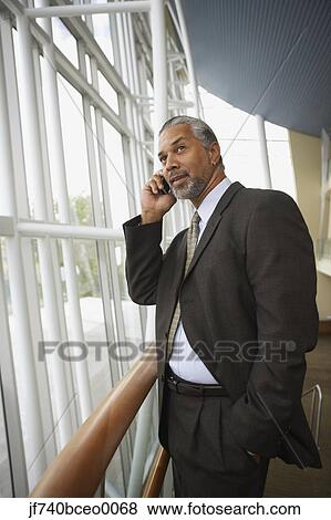 African businessman talking on cell phone next to window, North Bethesda, Maryland, United States View Large Photo Image Stock Photo - African businessman talking on cell phone next to window, North Bethesda, Maryland, United States. Fotosearch