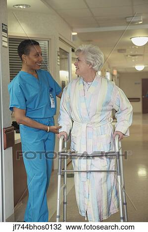 Stock Image - African female doctor helping patient with walker, Bethesda, Maryland, United States. Fotosearch