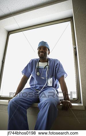 African male surgeon sitting in window alcove View Large Photo Image Stock Photo - African male surgeon sitting in window alcove. Fotosearch