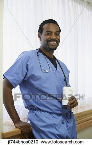 African male surgeon standing next to window drinking coffee View Large Photo Image Stock Image - African male surgeon standing next to window drinking coffee. Fotosearch