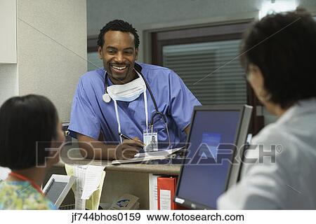 Stock Photo - African male surgeon talking to co-workers, Bethesda, Maryland, United States. Fotosearch