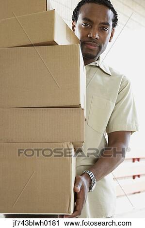 Stock Image - African man carrying boxes. Fotosearch