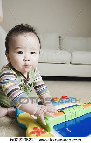 Stock Image - Asian baby playing on the floor. Fotosearch