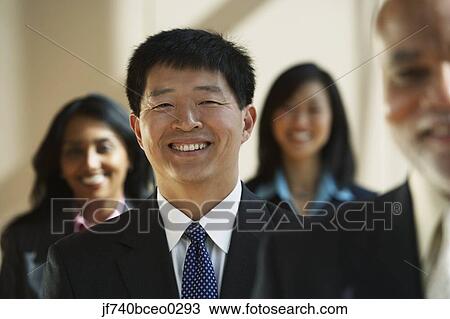 Asian businessman with co-workers in the background View Large Photo Image Stock Image - Asian businessman with co-workers in the background. Fotosearch