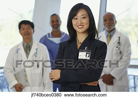 Asian businesswoman with doctors in the background View Large Photo Image Stock Image - Asian businesswoman with doctors in the background. Fotosearch