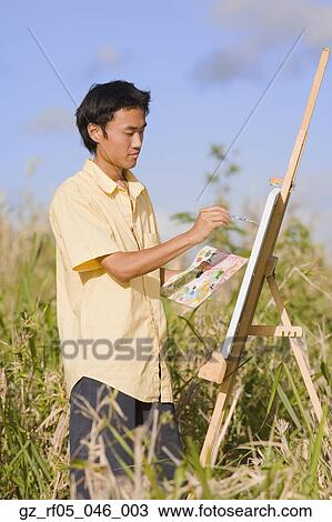 Asian man painting at easel outdoors, Florianopolis, Brazil View Large Photo Image Stock Image - Asian man painting at easel outdoors, Florianopolis, Brazil. Fotosearch