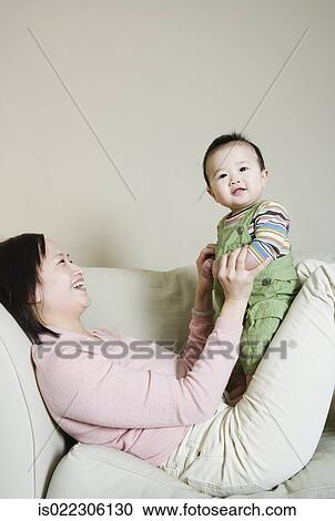 Asian mother and baby on the sofa View Large Photo Image Stock Image - Asian mother and baby on the sofa. Fotosearch