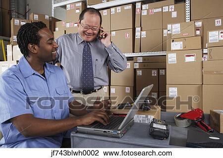 Businessman and co-worker in shipping department View Large Photo Image Stock Image - Businessman and co-worker in shipping department. Fotosearch