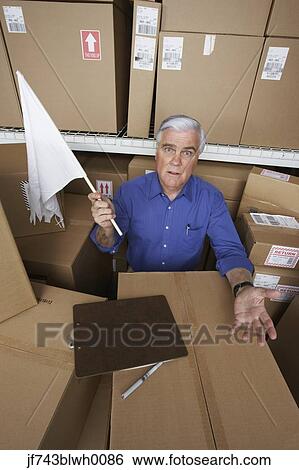 Businessman in warehouse waving white flag View Large Photo Image Stock Photograph - Businessman in warehouse waving white flag. Fotosearch