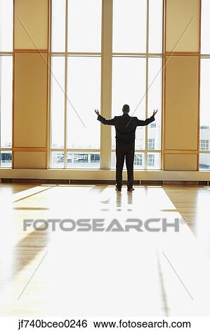 Businessman standing in sunlit room with arms outstretched, North Bethesda, Maryland, United States View Large Photo Image Stock Photograph - Businessman standing in sunlit room with arms outstretched, North Bethesda, Maryland, United States. Fotosearch