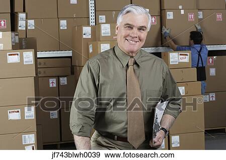 Businessman standing in warehouse View Large Photo Image Stock Photo - Businessman standing in warehouse. Fotosearch