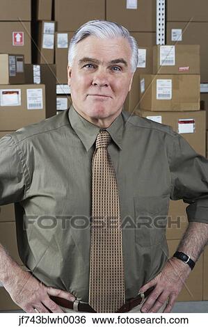 Stock Photograph - Businessman standing in warehouse. Fotosearch