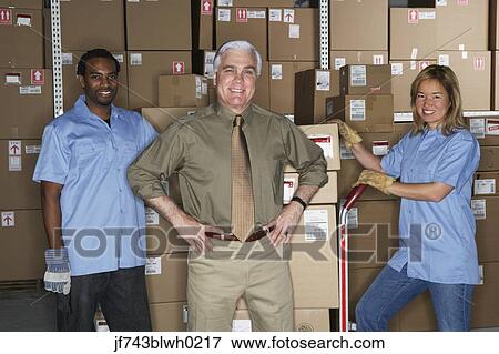 Businessman with warehouse workers in warehouse View Large Photo Image Stock Photo - Businessman with warehouse workers in warehouse. Fotosearch