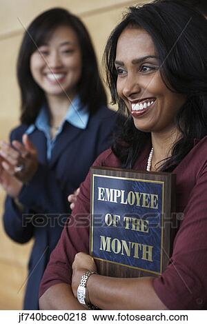 Businesswoman holding Employee of the Month plaque View Large Photo Image Stock Photo - Businesswoman holding Employee of the Month plaque. Fotosearch