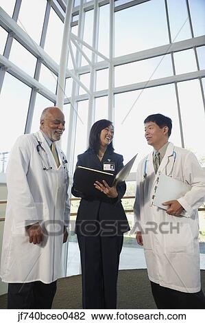 Businesswoman talking to two male doctors, North Bethesda, Maryland, United States View Large Photo Image Stock Image - Businesswoman talking to two male doctors, North Bethesda, Maryland, United States. Fotosearch