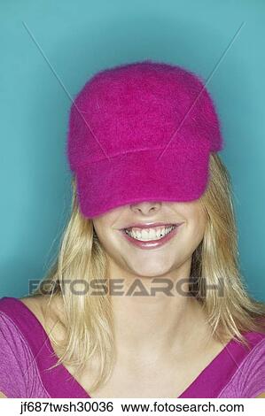 Close up of girl smiling with hat covering her eyes View Large Photo Image Stock Photograph - Close up of girl smiling with hat covering her eyes. Fotosearch