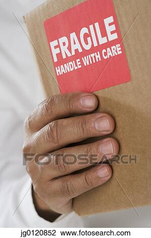 Close up of male hand holding package with fragile sticker View Large Photo Image Stock Image - Close up of male hand holding package with fragile sticker. Fotosearch