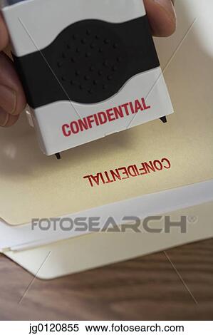 Close up of male hand using confidential stamp on file View Large Photo Image Stock Photography - Close up of male hand using confidential stamp on file. Fotosearch