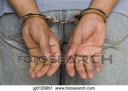 Close up of male hands in handcuffs View Large Photo Image Stock Image - Close up of male hands in handcuffs. Fotosearch