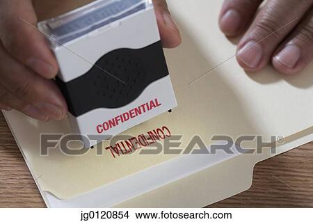 Close up of male hands using confidential stamp on file View Large Photo Image Picture - Close up of male hands using confidential stamp on file. Fotosearch