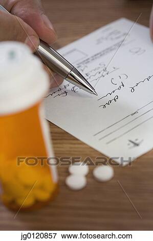 Close up of man filling out prescription View Large Photo Image Stock Photo - Close up of man filling out prescription. Fotosearch
