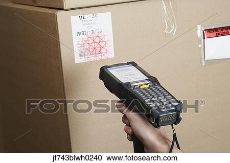 Stock Image - Close up of scanner gun scanning package . Fotosearch