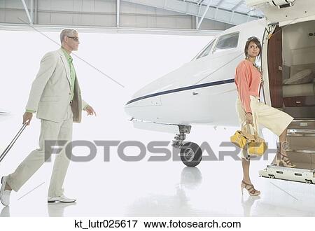 Couple boarding airplane in hanger, Nobato, California, United States View Large Photo Image Stock Photo - Couple boarding airplane in hanger, Nobato, California, United States. Fotosearch