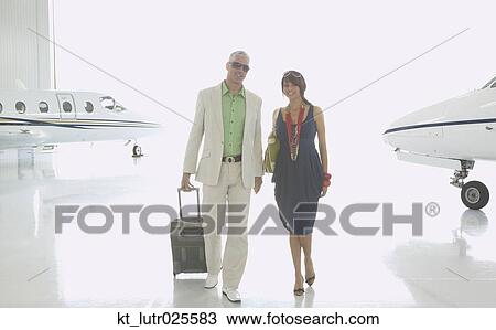 Couple walking in airplane hanger, Nobato, California, United States View Large Photo Image Stock Image - Couple walking in airplane hanger, Nobato, California, United States. Fotosearch