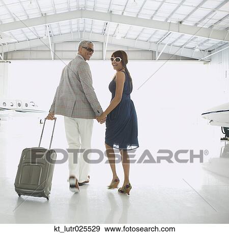 Couple walking out of airplane hanger, Nobato, California, United States View Large Photo Image Stock Photo - Couple walking out of airplane hanger, Nobato, California, United States. Fotosearch