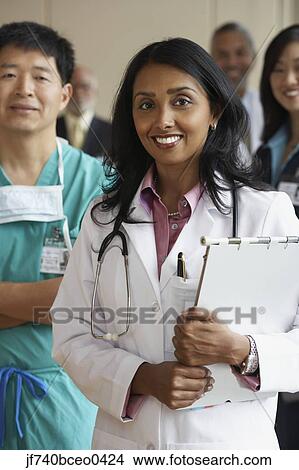 Female Indian doctor with co-workers in the background View Large Photo Image Picture - Female Indian doctor with co-workers in the background. Fotosearch