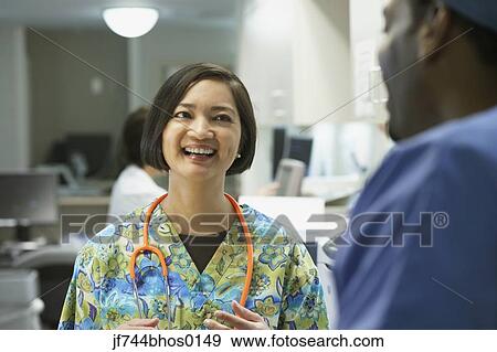 Stock Photo - Female nurse talking to co-worker, Bethesda, Maryland, United States. Fotosearch