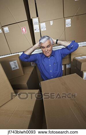 Stock Image - Frustrated businessman in warehouse . Fotosearch