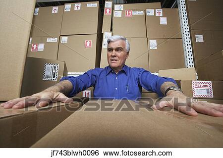 Stock Photograph - Frustrated businessman in warehouse . Fotosearch