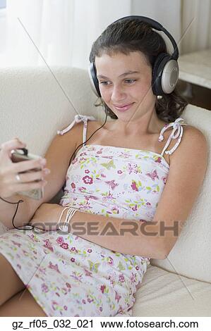 Girl listening to music on sofa View Large Photo Image Stock Image - Girl listening to music on sofa. Fotosearch