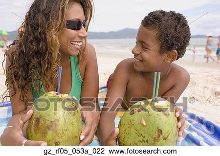 Hispanic mother and son lying on the beach drinking from coconuts, Florianopolis, Brazil View Large Photo Image Stock Image - Hispanic mother and son lying on the beach drinking from coconuts, Florianopolis, Brazil. Fotosearch