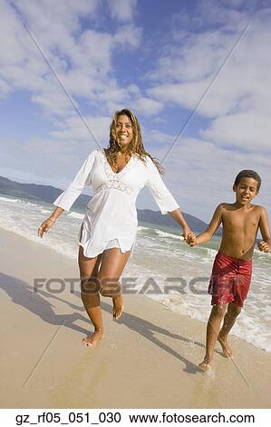 Hispanic mother and son running in the surf, Florianopolis, Brazil View Large Photo Image Stock Image - Hispanic mother and son running in the surf, Florianopolis, Brazil. Fotosearch