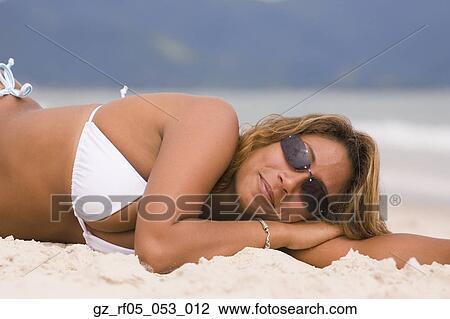 Stock Image - Hispanic woman lying on the beach, Florianopolis, Brazil. Fotosearch