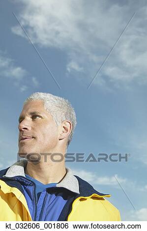 Stock Photograph - Low angle view of middle-aged man under blue sky, California, United States. Fotosearch