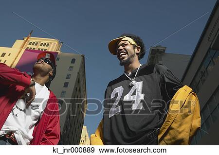 Low angle view of two young African men standing in urban area, Oakland, California, United States View Large Photo Image Stock Photo - Low angle view of two young African men standing in urban area, Oakland, California, United States. Fotosearch
