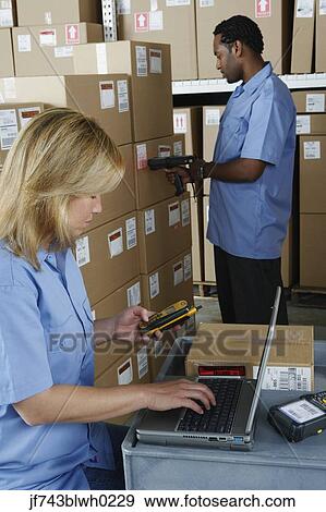Stock Photo - Male and female warehouse workers in warehouse. Fotosearch